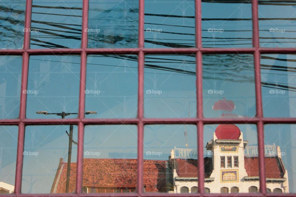 Portrait reflection of a building from the Dutch colonial heritage on a building window framed by wooden windows, namely the European-style maritime museum, Jakarta, Indonesia.