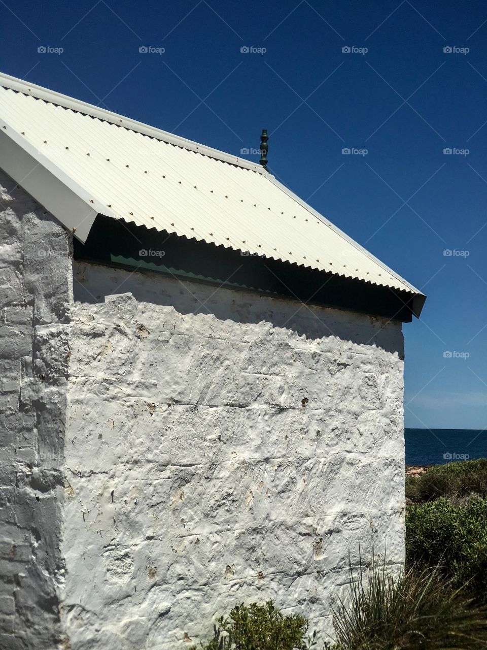 Old stone lighthouse keepers house ocean background 