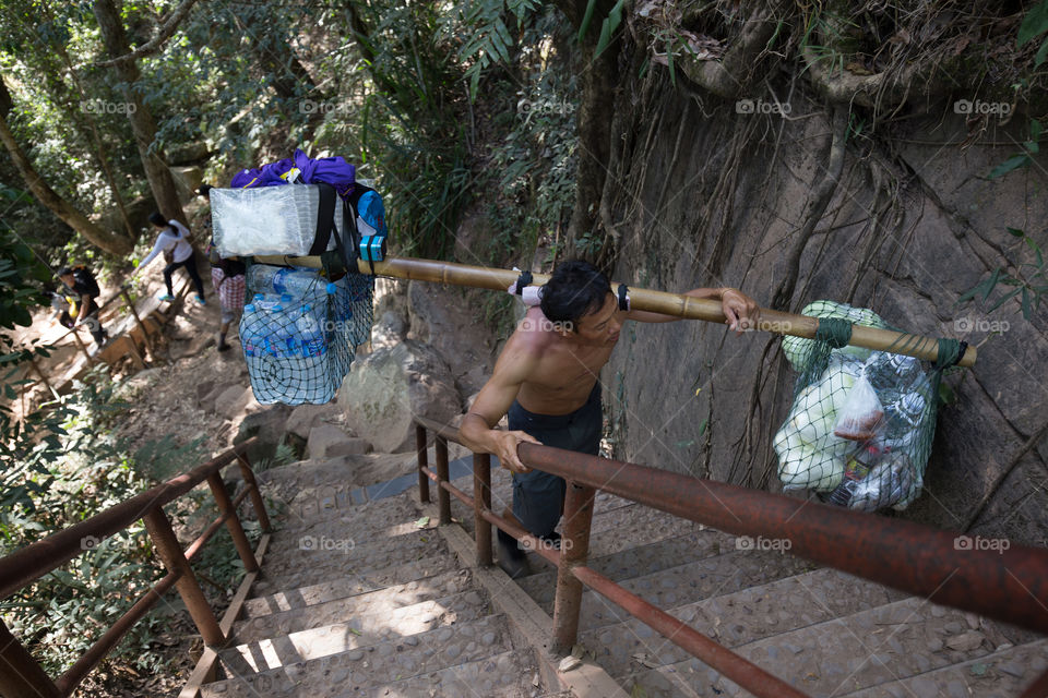 Man carrying stuff on the shoulder 