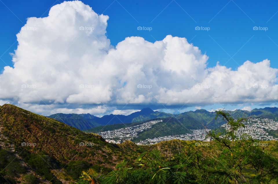 Diamond Head Hawaii, view from top of the mountain. Blue Skies, large white clouds, mountains and towns