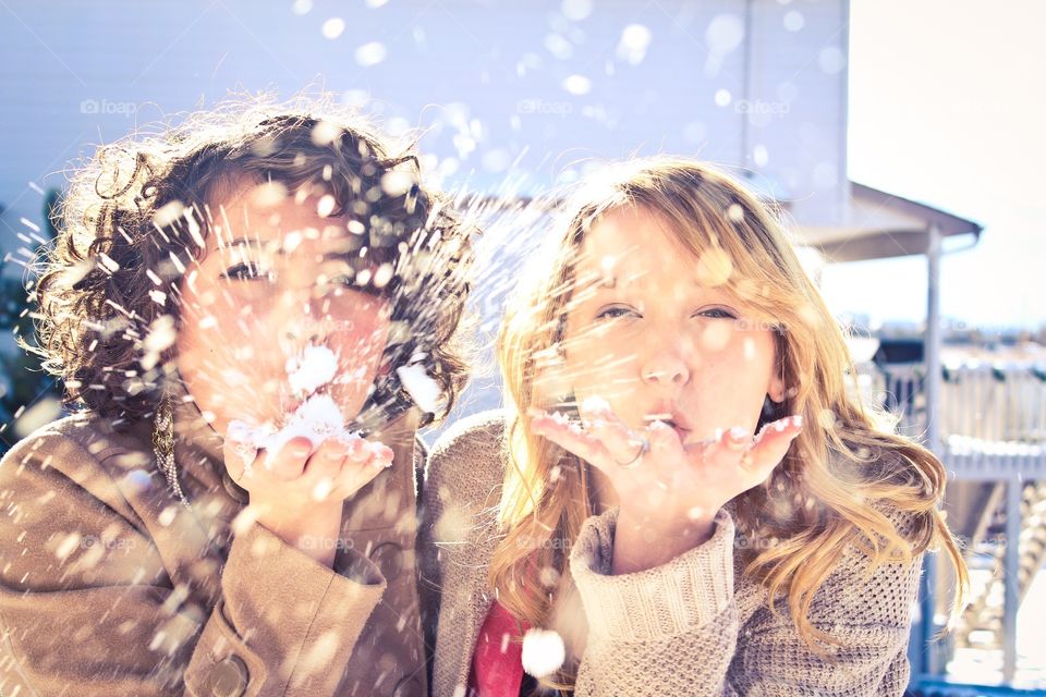 Girls blowing snow. 