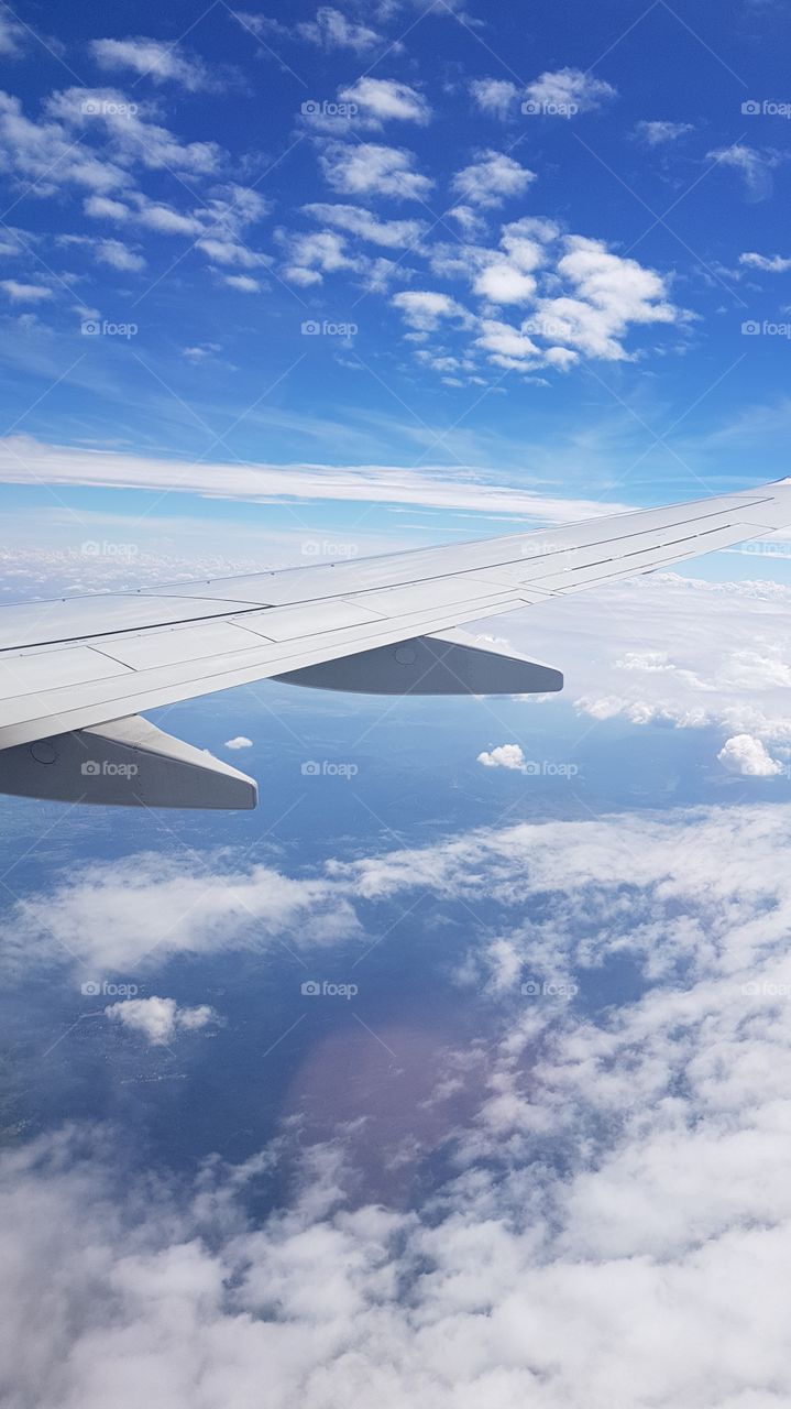 plane window view on clouds and atlantic ocean