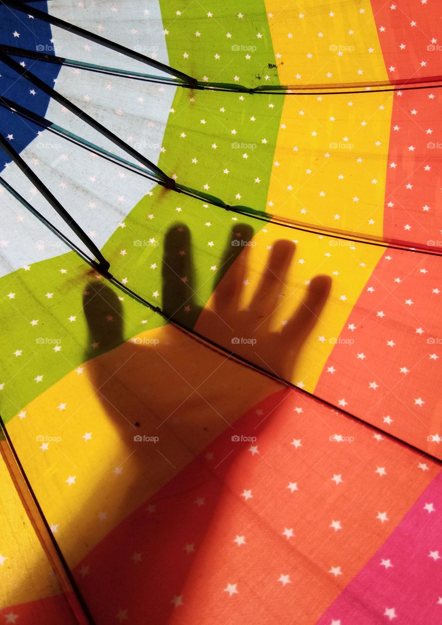 hand shadow on colorful umbrella