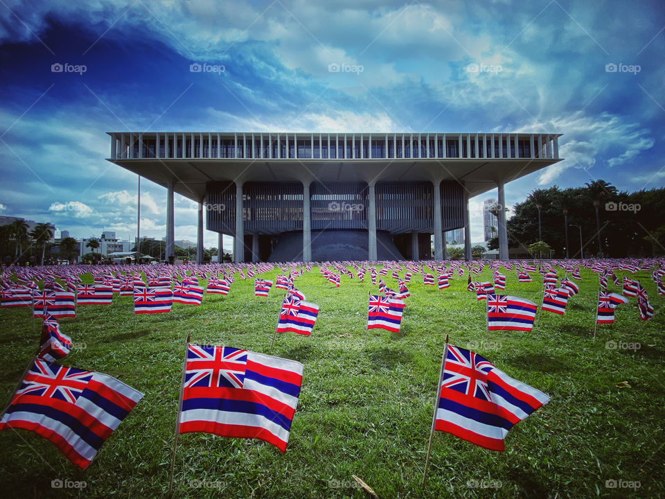Hawaii state capital building with Hawaii state flags on the capital grounds 