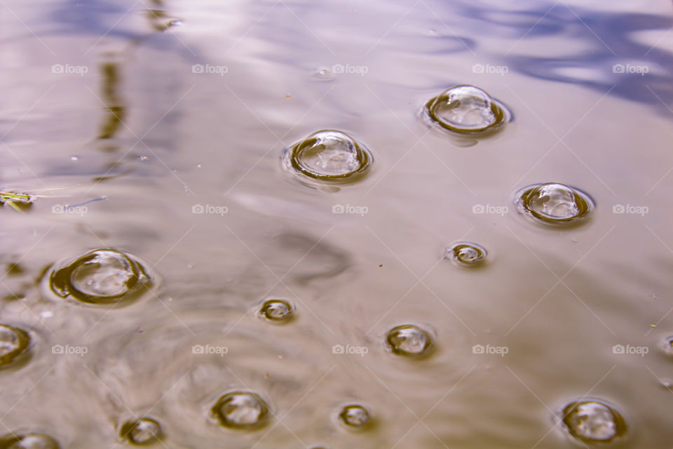 bubbles floating on the water surface creating a reflection