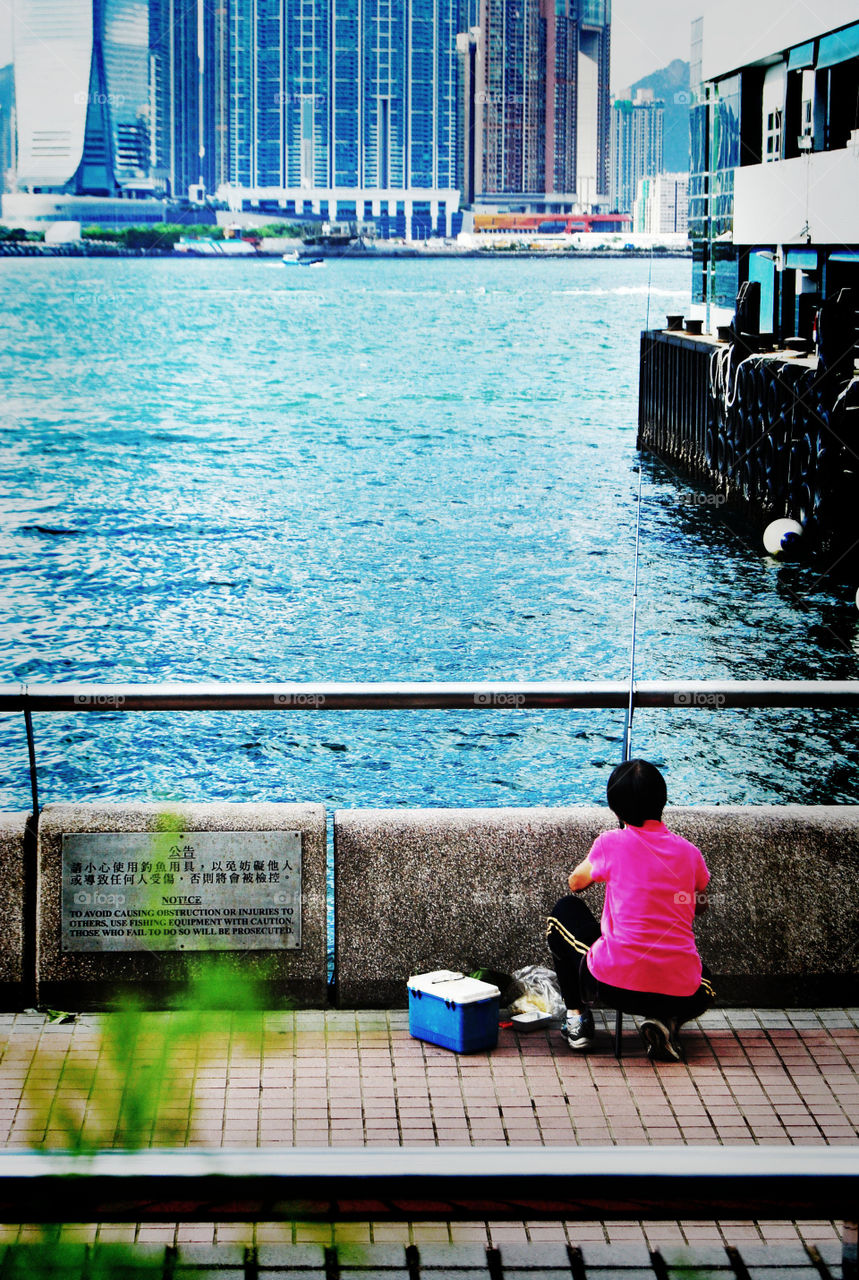 photo story, Old lady setting up her rod for fishing in the city bay area