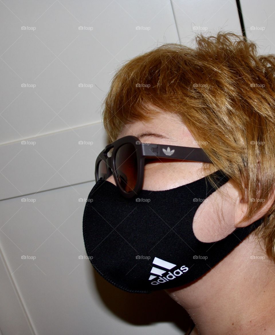 The model wears a mask to protect herself from the virus. Both the mask and the glasses are from adidas. The photograph has been taken from close up so that it can be appreciated well.