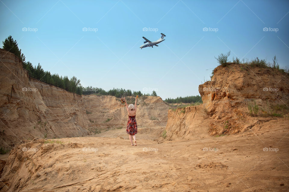 A girl is waving hands to a plane