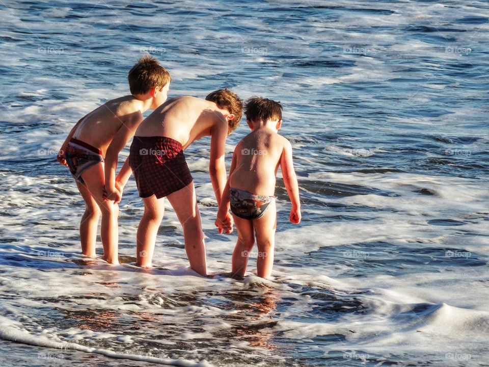 Three Brothers Holding Hands By The Shore. Brothers Holding Hands