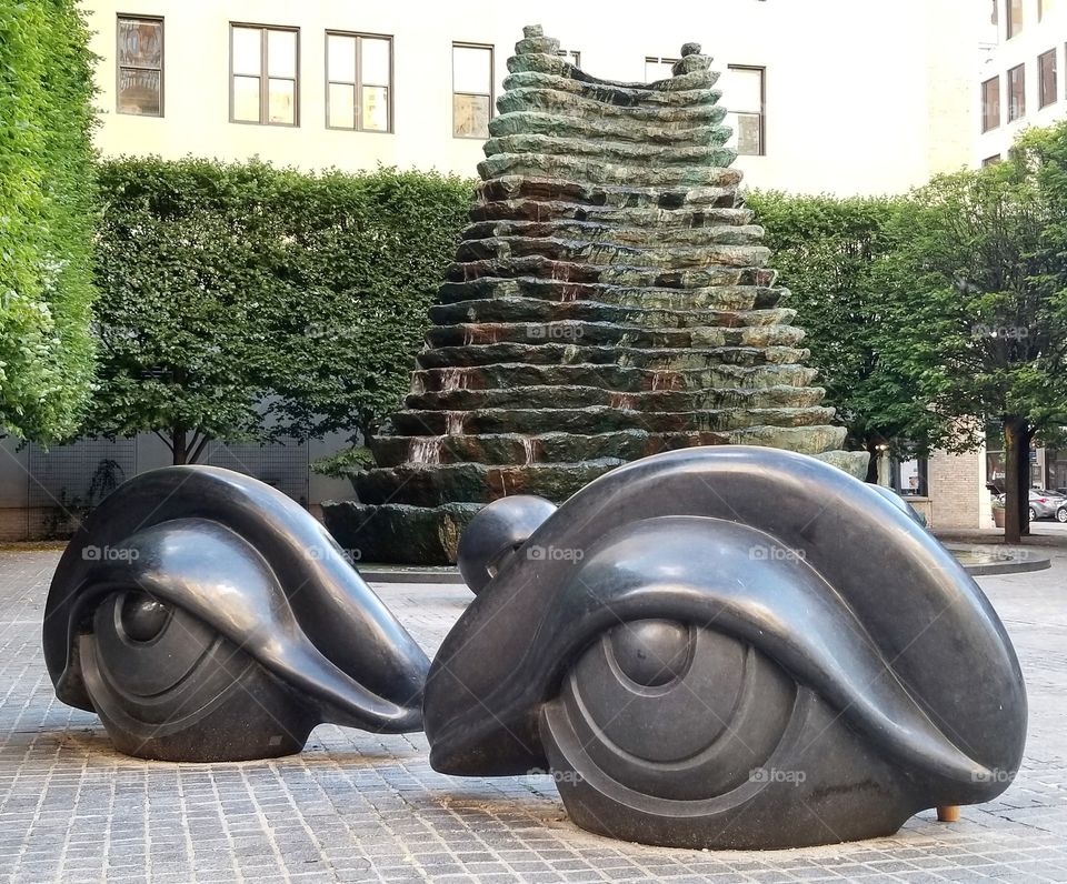 Benches shaped like eyes in front of a fountain at Agnes R. Katz plaza in downtown Pittsburgh