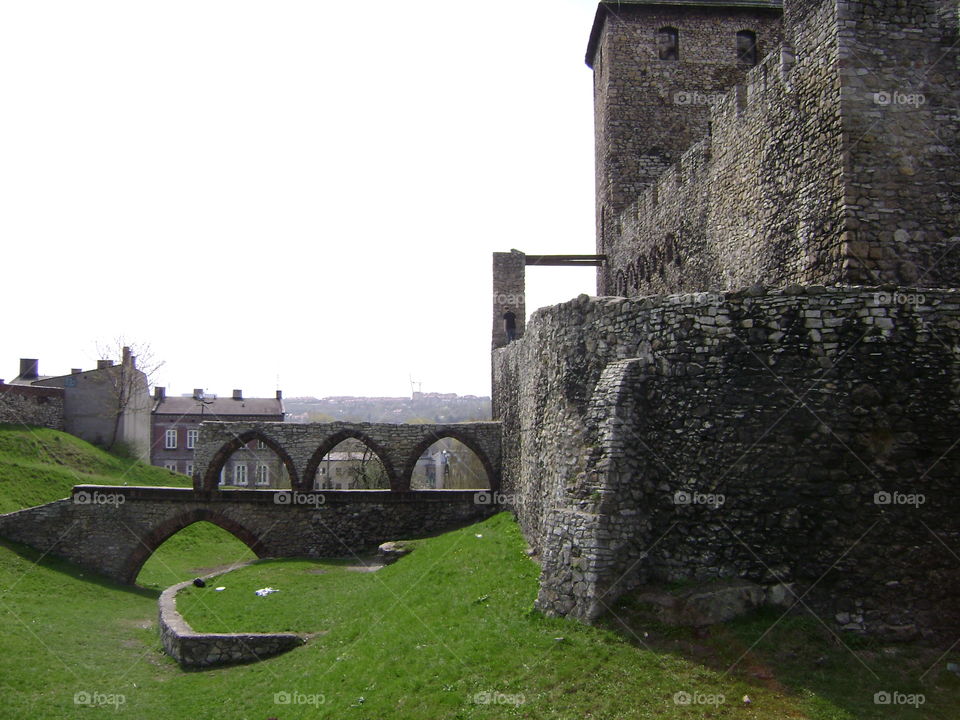 The grounds behind a castle with a wall in ruins. 