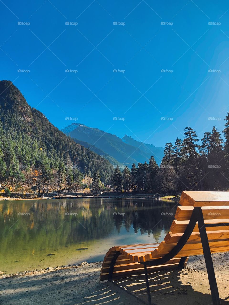 A bench by the lake against the background of mountains