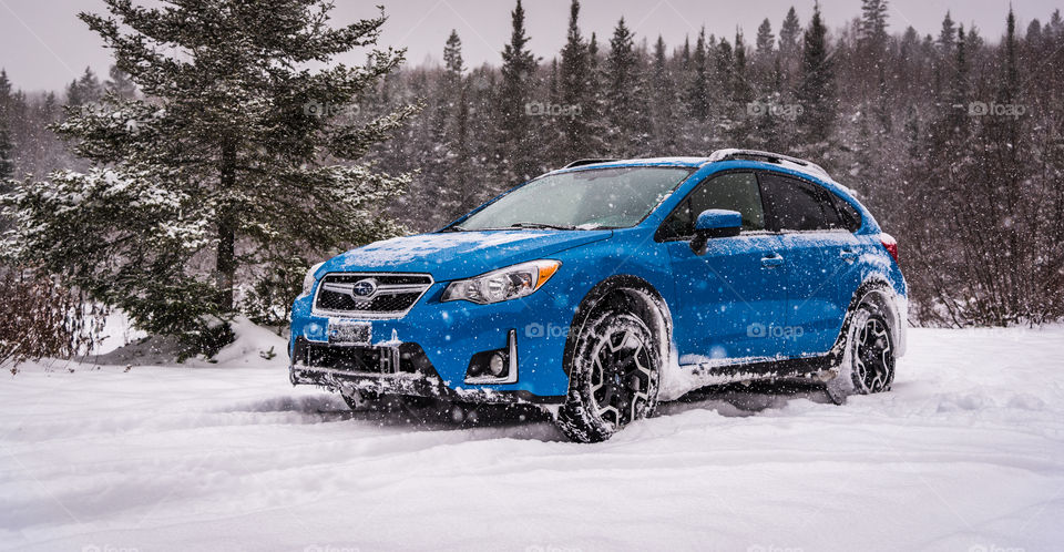 Blue sport utility vehicle into snowstorm on a photography journey in the outdoors