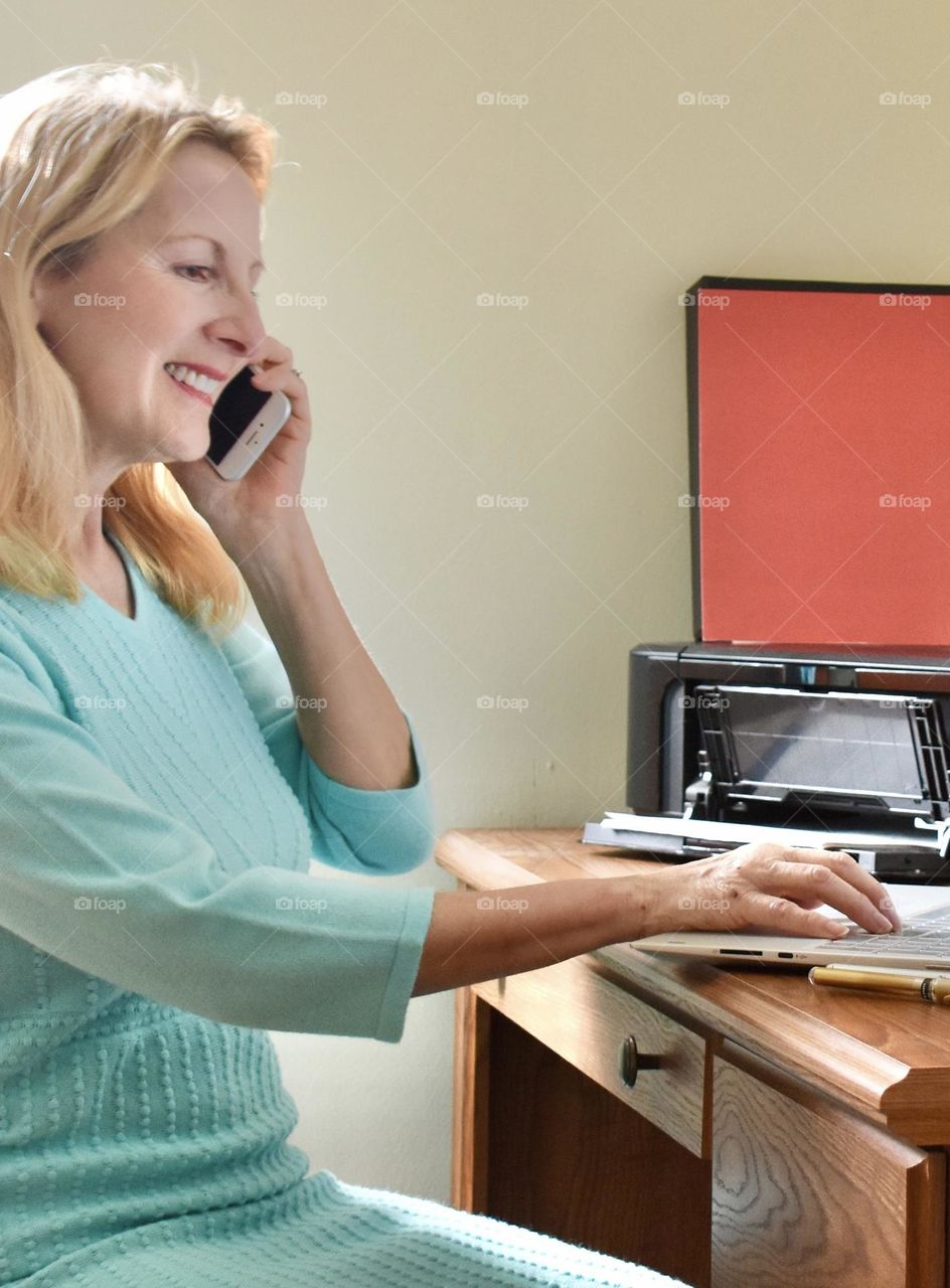 Woman using phone at desk