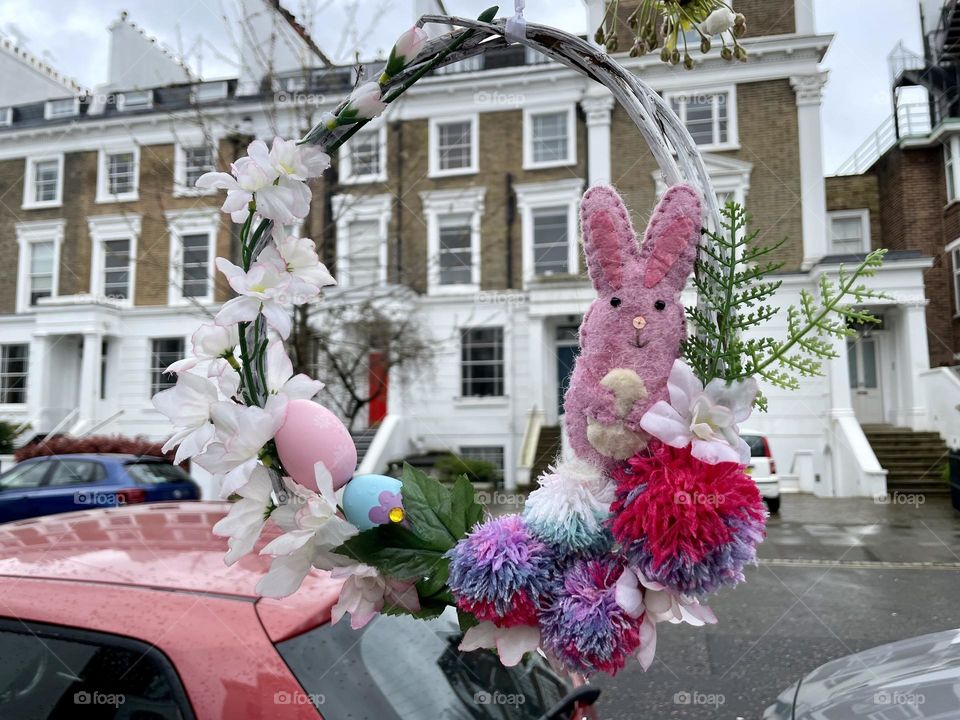 An Easter decorated wreath dangling from a tree in a street in London 