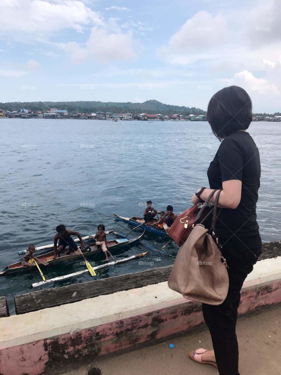 Basilan Province
Philippines
They are coins divers..the Badjaos or sea gypsies.. 
They won't take free money they will want you to throw the coins in the water and they will show off their diving skills