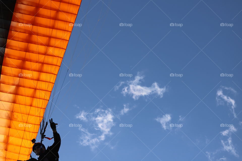 Paraglider against blue sky