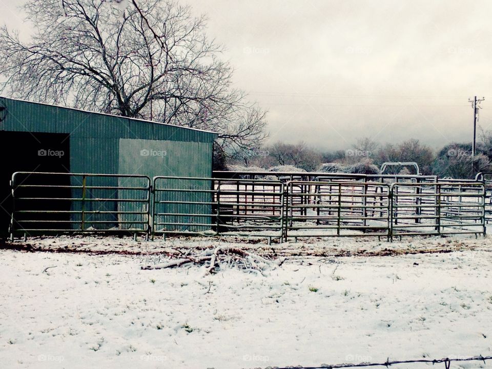 Texas pasture and barn sprinkled with snow. 