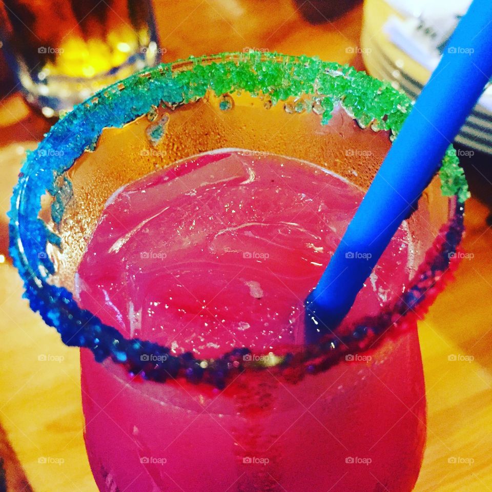 Fruity cocktail with rainbow sugar rim 