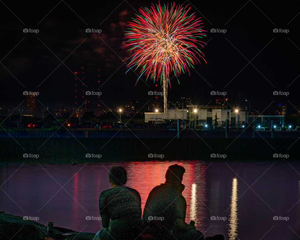 Two people watching fireworks display on the Fourth of July in Milwaukee Wisconsin