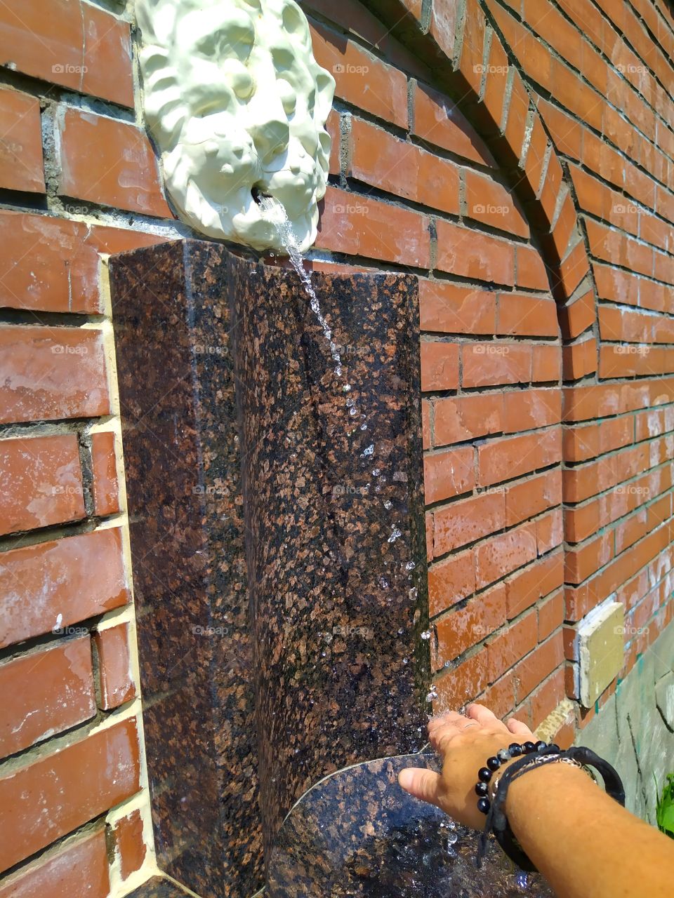 Marble antique drinking column on which the cardinal points are carved in Latin