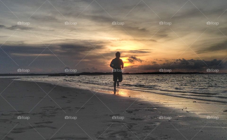 Silhouette of a man running at beach