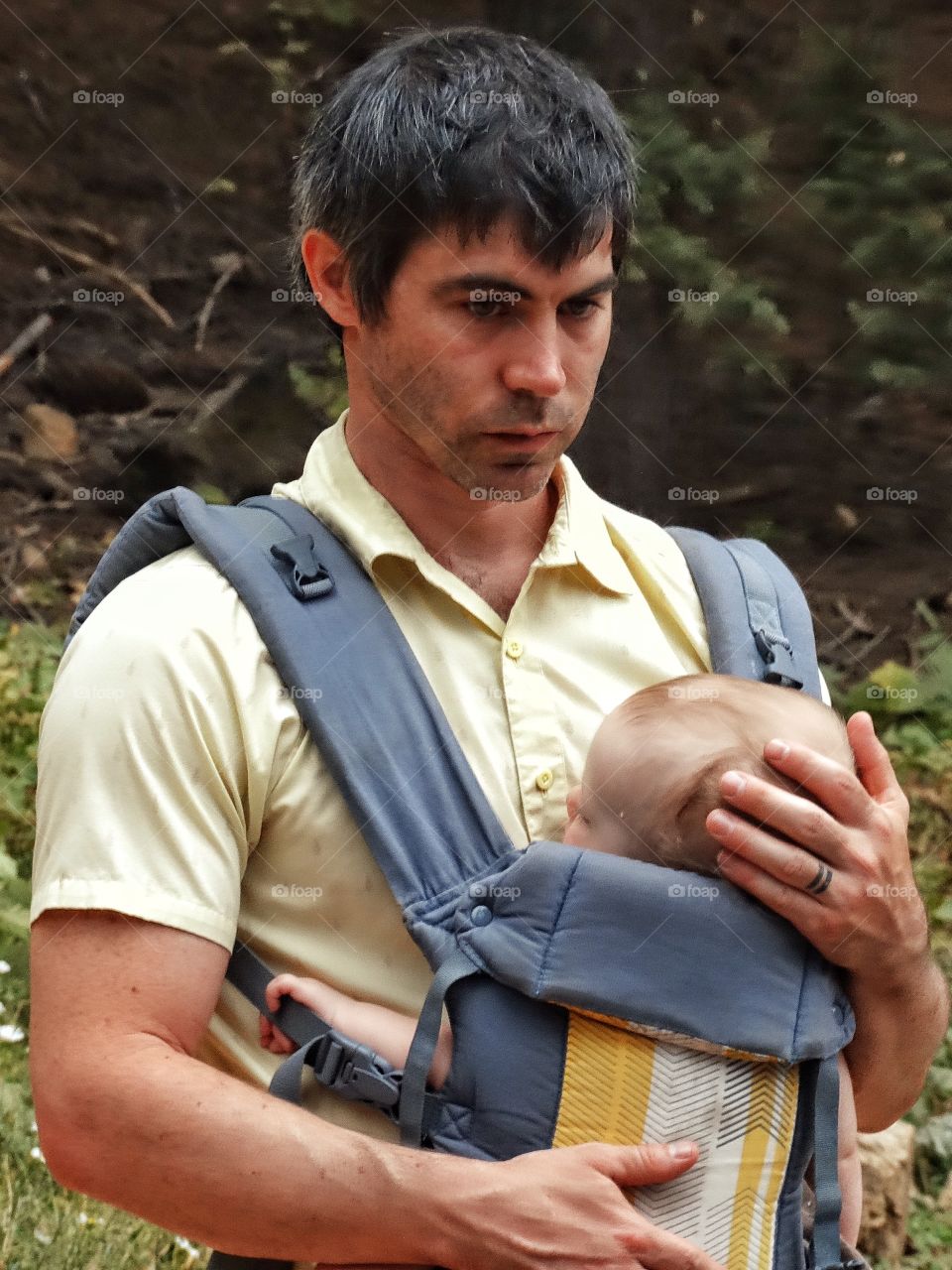Young Father. New Father Holding His Baby In A Chest Sling
