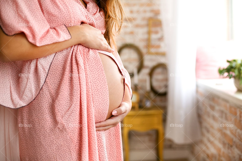 Pregnant woman showing her abdomen