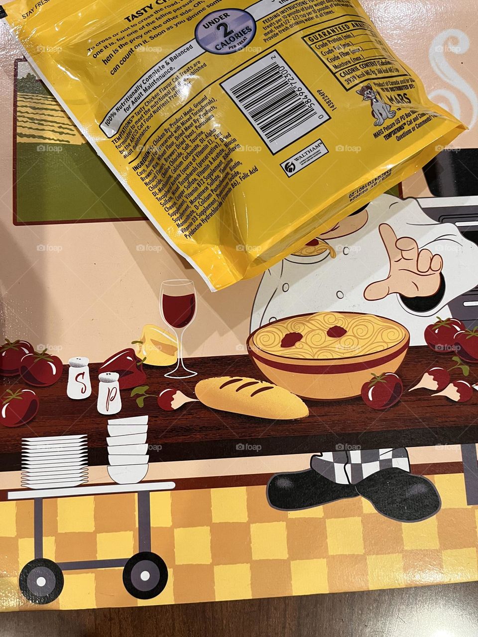 Bright yellow bag of treats on a yellow place mat.