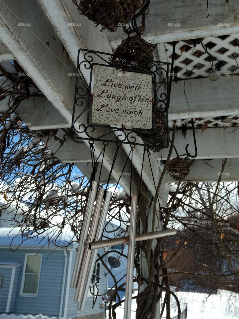 wind chimes hanging from the pergola in the winter