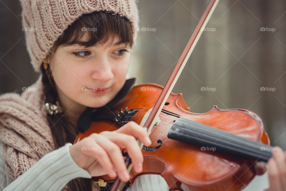 Teenage girl portrait with violin in winter park