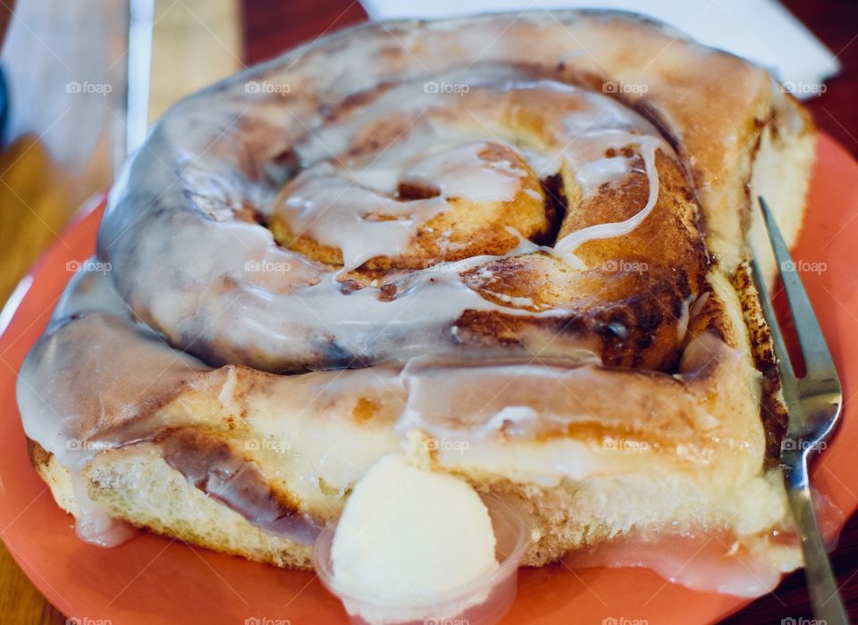 Huge Delicious Cinnamon Roll with a pat of butter 