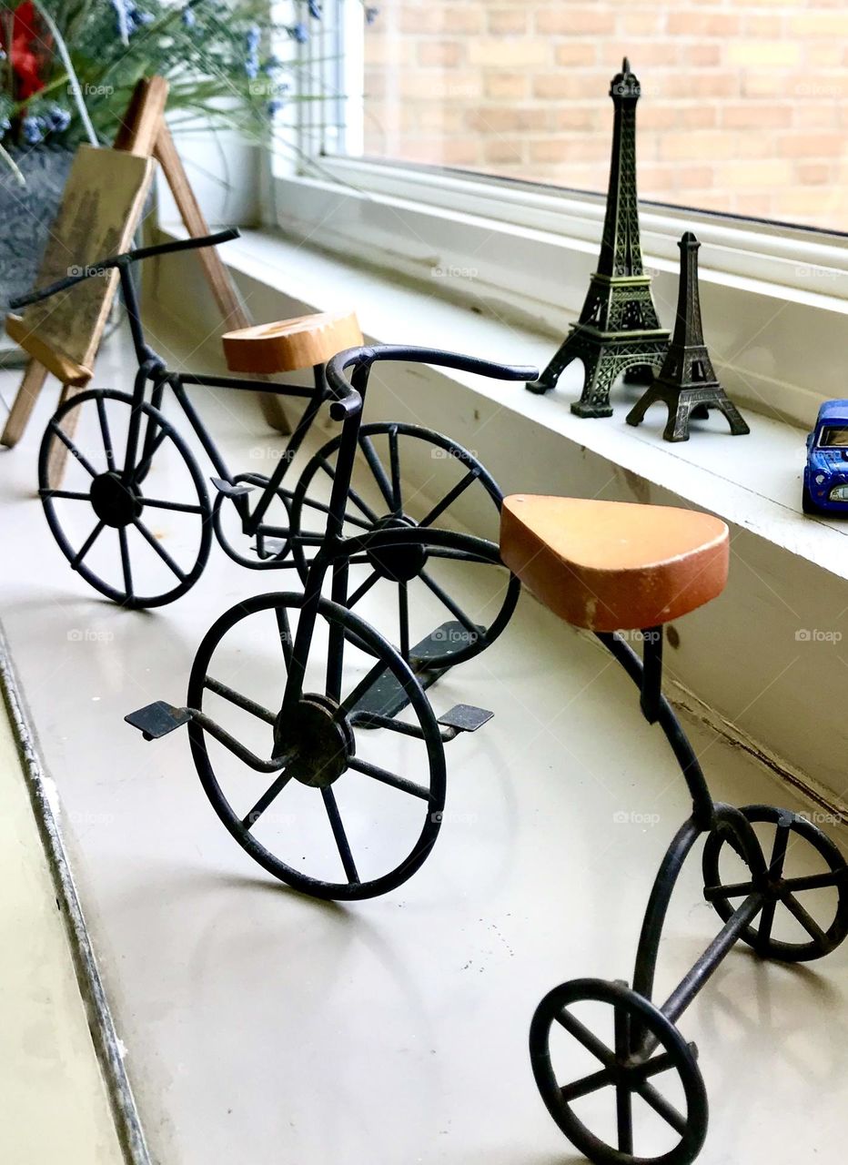 Miniature bicycles displayed on windowsill 