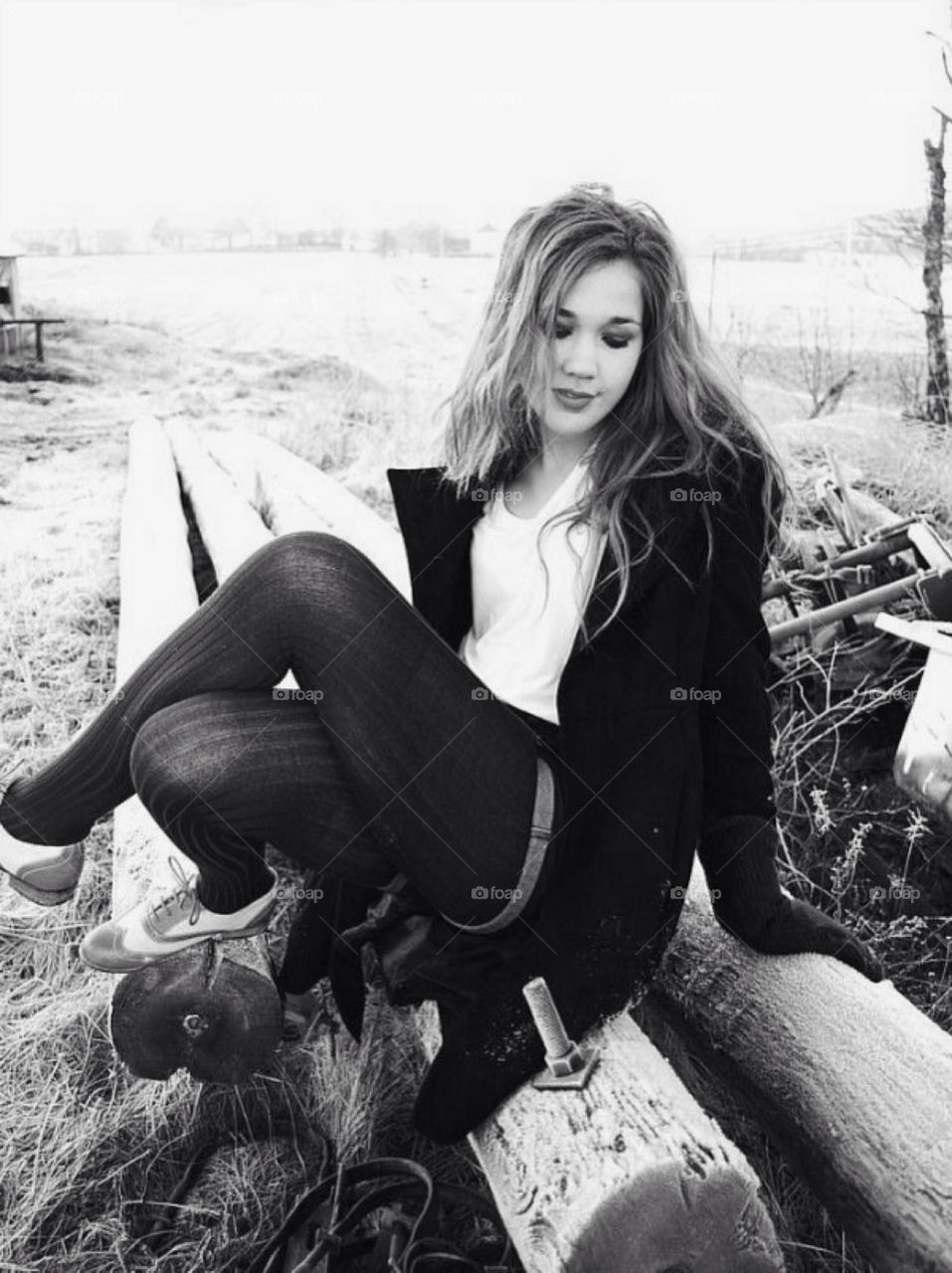 A girl in a winter scenery. A young girl outside an old farm a winter day