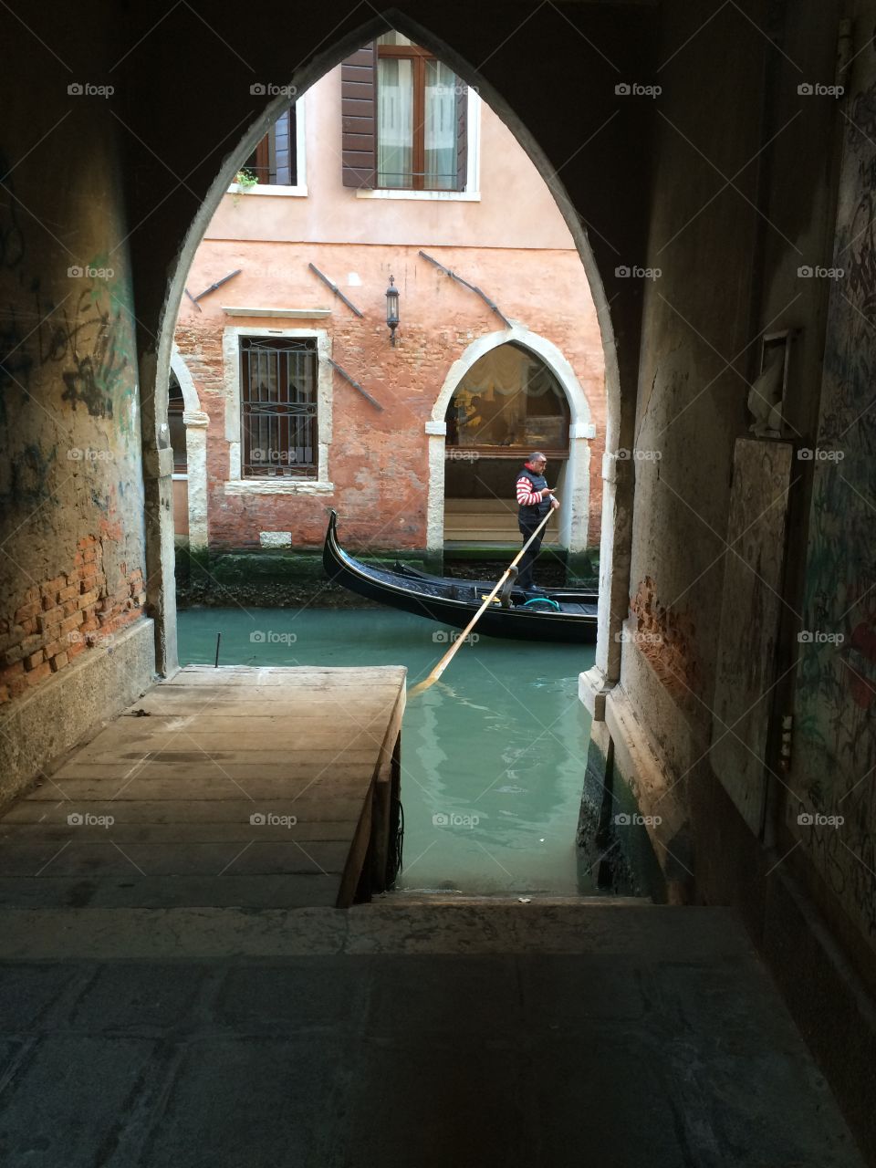 Dead end road in Venice with Gondola passing by on the canal. 