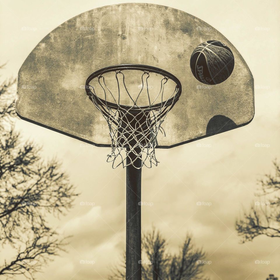 Monochromatic basketball hoop shot, shooting hoops on the basketball court, basketball about to score, basketball about to go in the hoop, scoring in basketball 