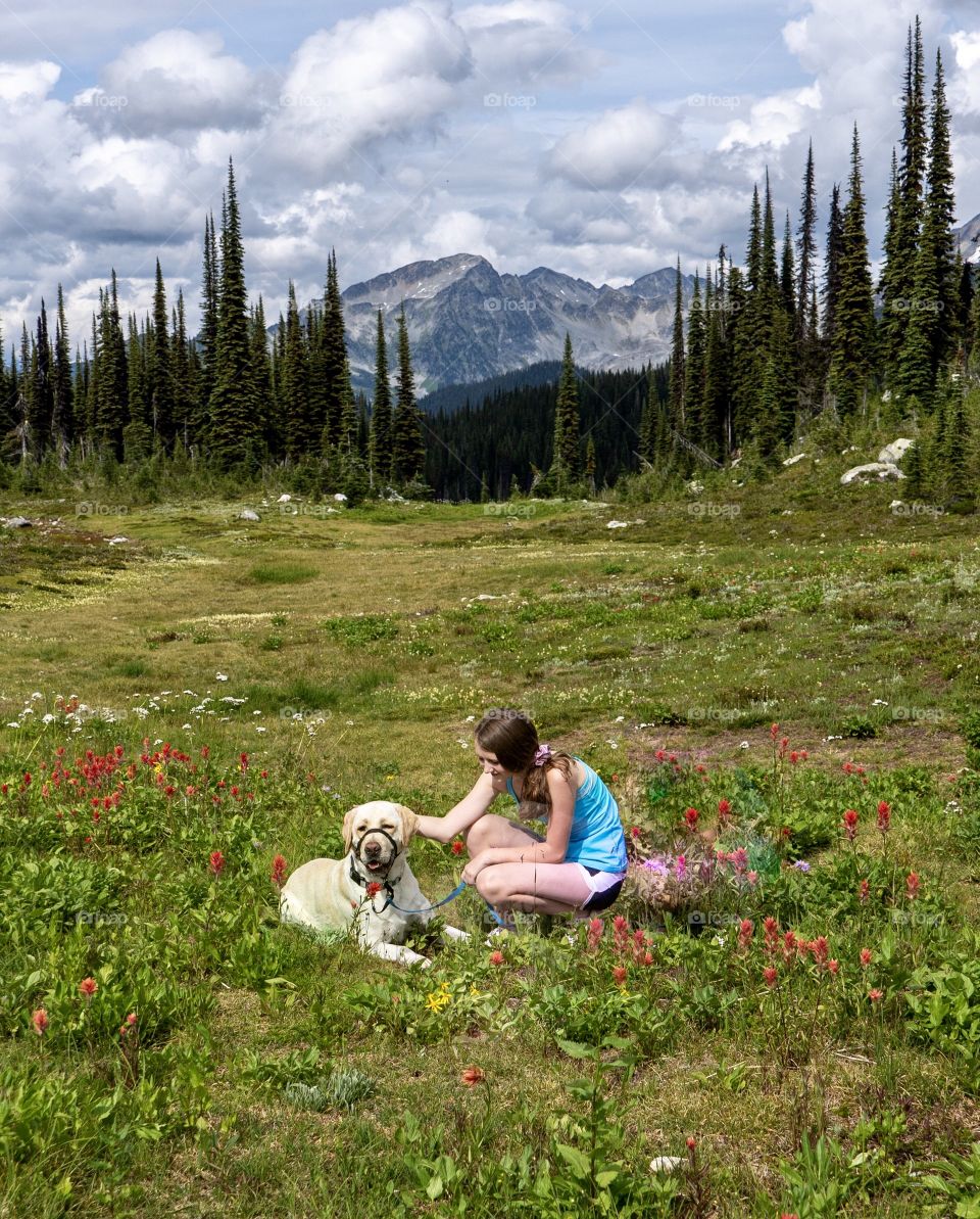 Girl and her dog taking a break during a mountain adventure 