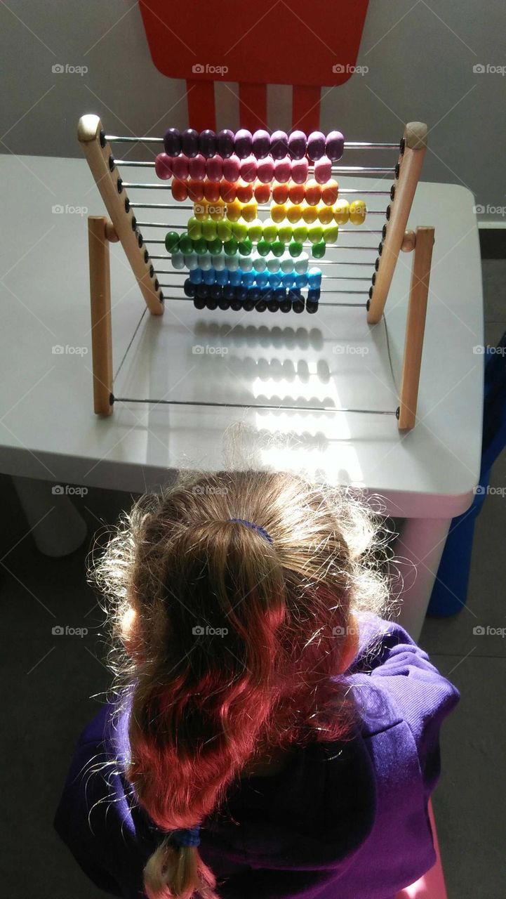 A child plays by Colored pellet setup.