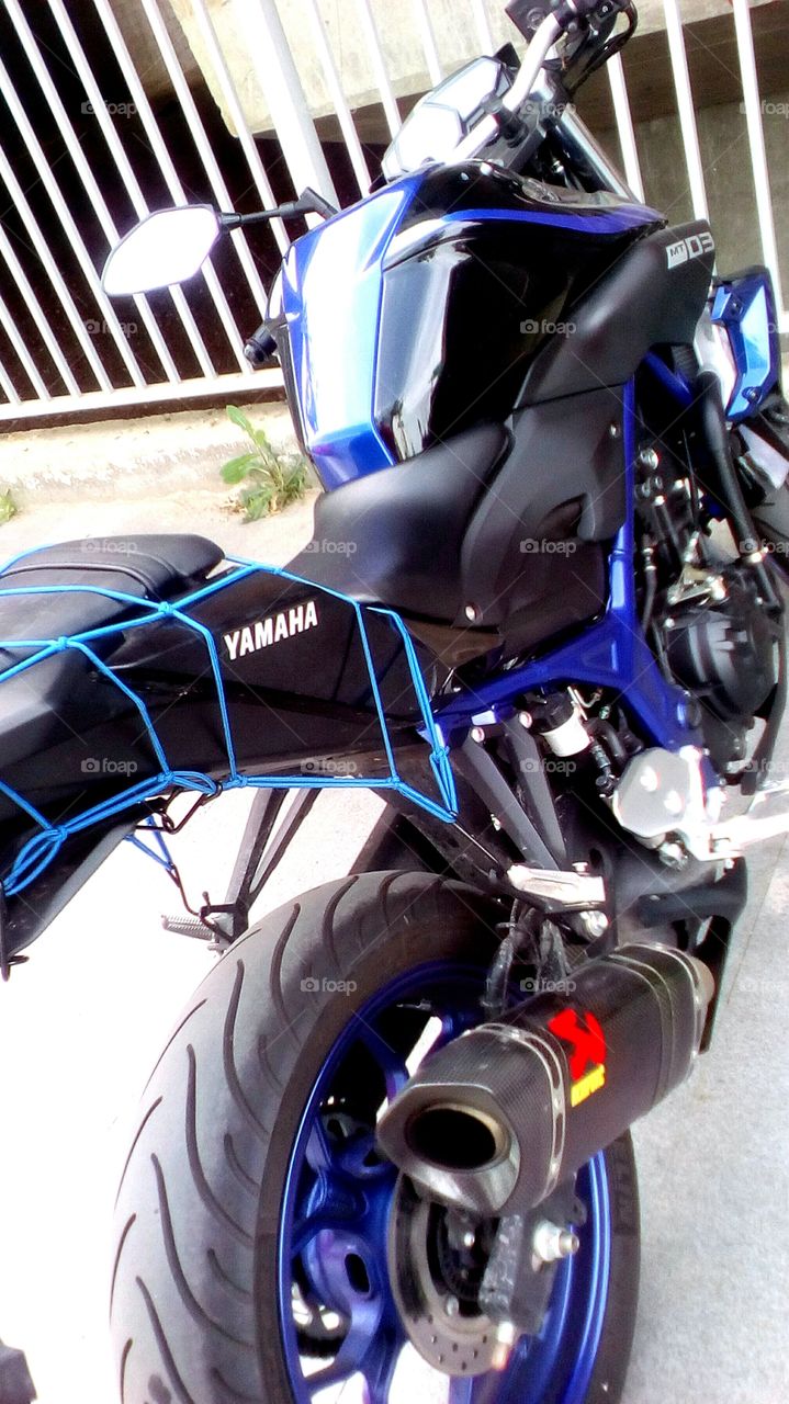 Blue indigo famous Yamaha brand 
motorcycle parking outdoors in sunnyday