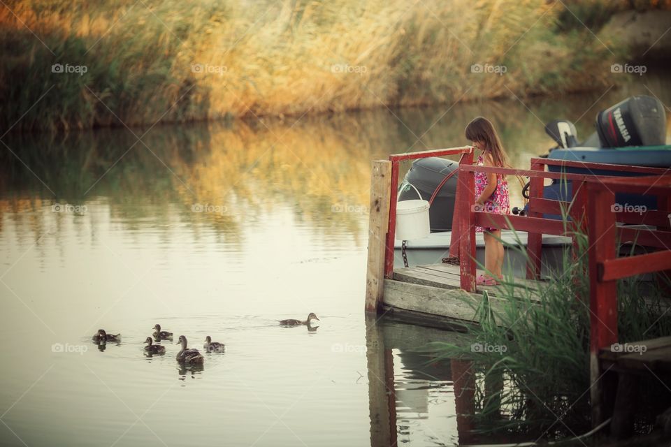 Little sisters near lake at sunset