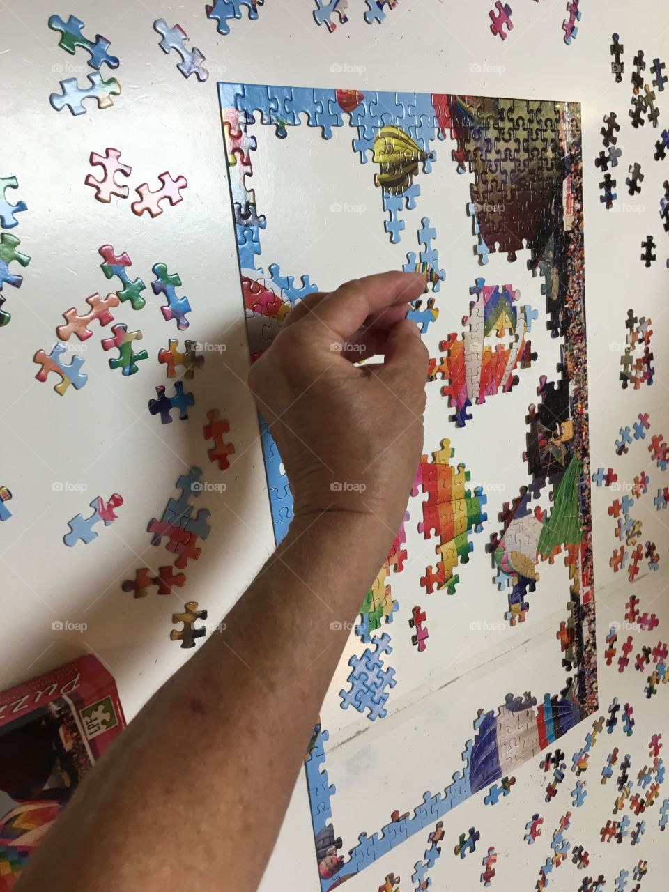 Putting a colorful puzzle together when it’s done it’ll be full of hot air balloons.