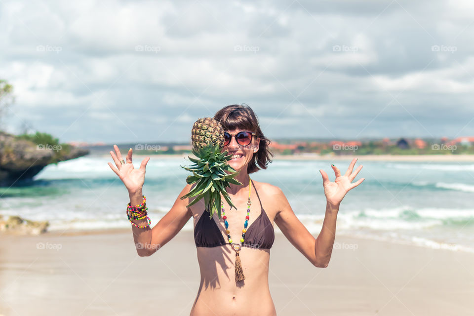 Fun on the beach with pineapple. Bali island.