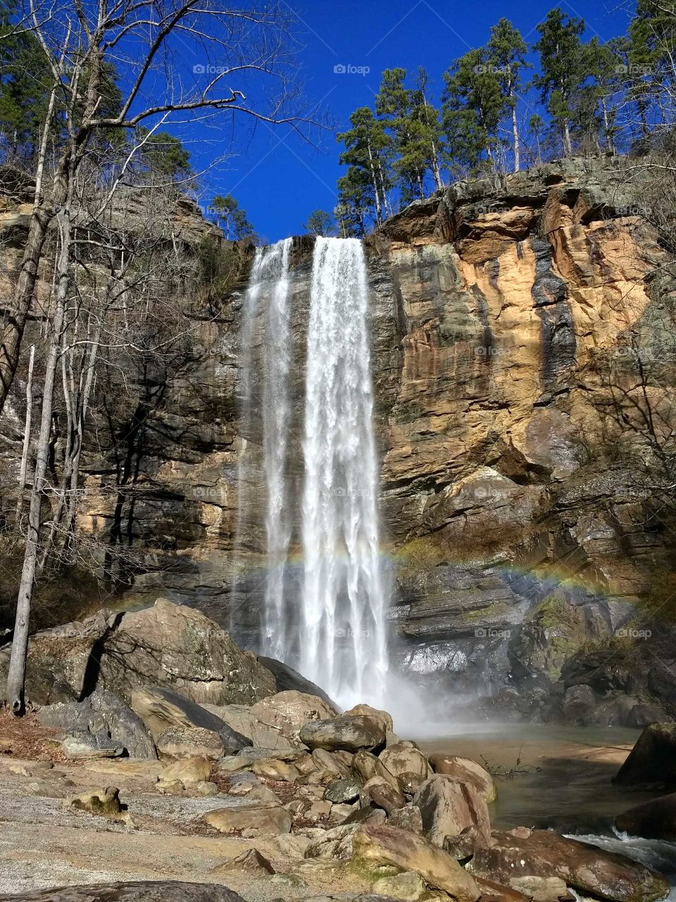 Beautiful waterfall with a rainbow and blue sky