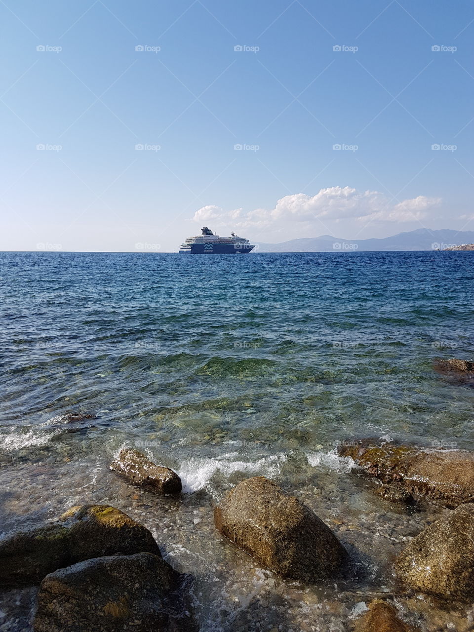 mykonos view of the beach and clouds and boat