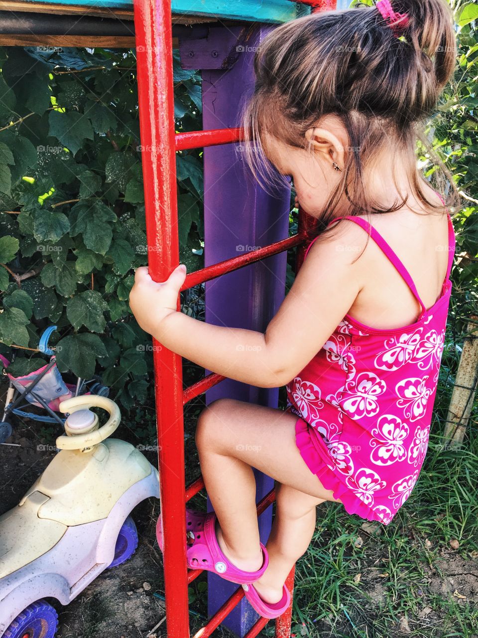 Little girl climbing ladder in park