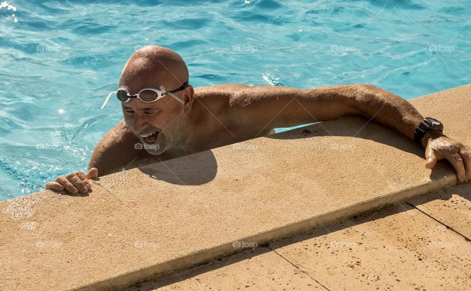 A man laughs heartily while enjoying time in the swimming pool