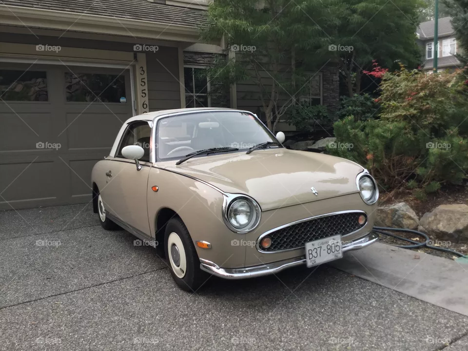 Nissan Figaro in a driveway 