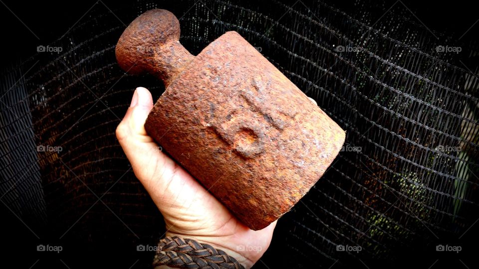 Um peso/medida de ferro velho enferrujado, de balança antiga equivalente há 5kg.
