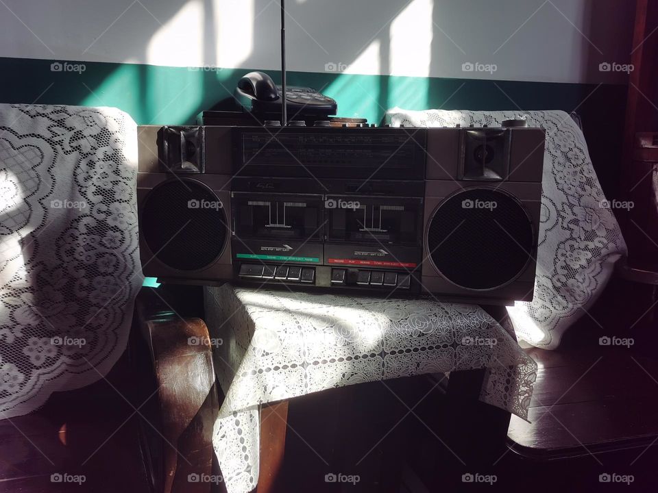 The old desk. The sunshine on the old radio,the picture shows the office state of different ages,the same efforts and progress.