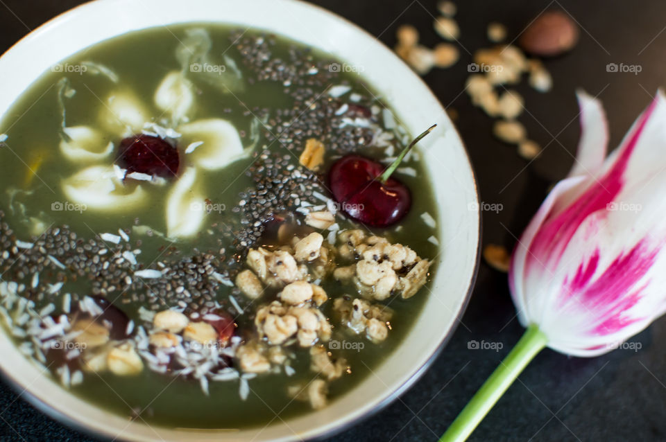 Green fruit smoothie bowl with zen white flower